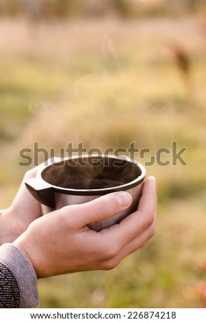 Vacuum cup in hands on autumn background