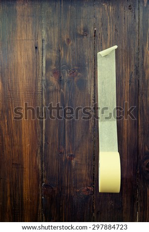 Yellow masking tape on wooden background