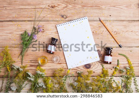 fragrant oil in the bottles, herbs and blank notepad