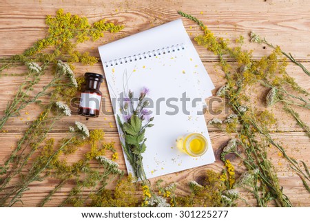 fragrant oil in the bottles, herbs and blank notepad