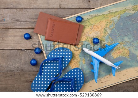 Christmas vacation concept - plane, map, passport on the wooden desk
