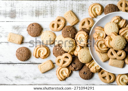 Chocolate chip and butter cookies with white ceramic dish on wood table
