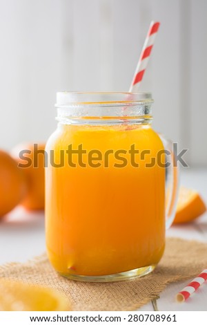 Fresh orange juice in the mason jar on wood table