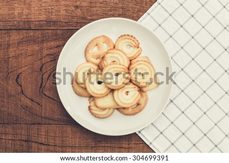 Danish butter Cookies in white ceramic dish on wood board, vintage style