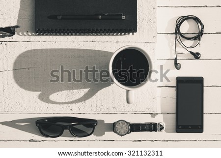 A cup of black coffee and casual business outfits on wood board background, Vintage black and white photography with a cup of coffee and business outfits