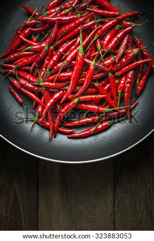 Red Hot Chili Peppers in old pan on rusty steel  background, Still life photography with overhead view of chili pepper on wood background, Dark mood of food photography with red chili peppers
