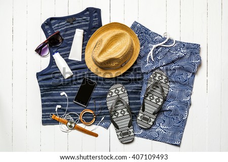 Overhead view of men's casual outfits of traveler, Summer holiday background, Beach accessories on white wood board, Vacation and travel items