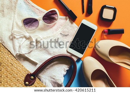 Flat lay photography with Smart phone and essential items for woman, Overhead view of essential beauty items, Top view of Smart phone with cosmetics and female accessories