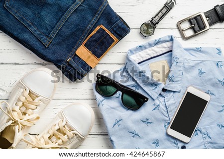 Men's casual outfits on wood board background, Essential vacation items for traveler