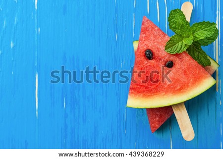 Watermelon slice popsicles on a blue rustic wood background, Popular summer fruit with yummy watermelon