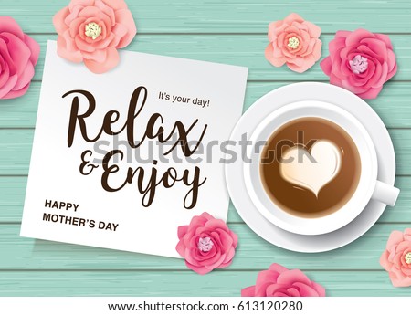 Flat lay style mother\'s day greeting card with coffee, flowers and white note paper on wooden table.