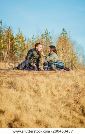 lovely couple boy and girl hugging, kissing and enjoying each other in nature and have a great picnic