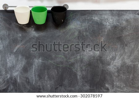 Blackboard with chalk marks and coloured cups