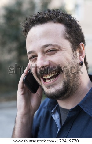 Laughing man phoning in the park