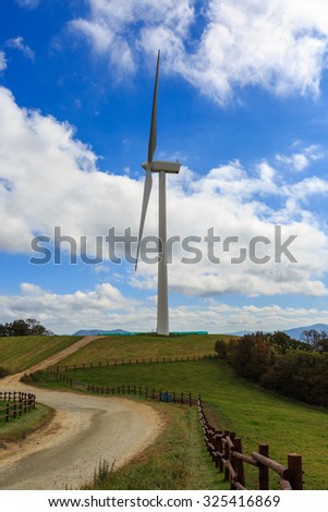 Farm Wind turbines generating electricity on green meadow in South Korea