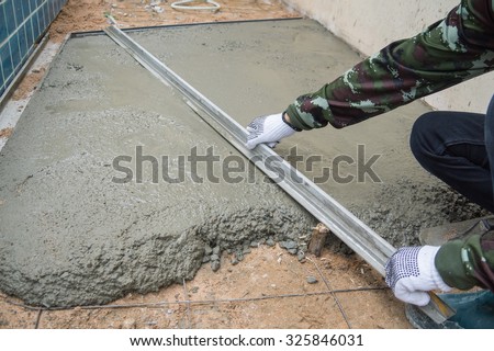 Worker making the level of the concrete slab.