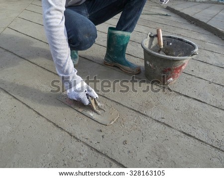 Worker making the level of the concrete slab.