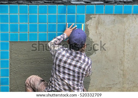 Tiled pool. The man hand while using spacer for installing tiles. construction work.Construction Pool.Technicians are tiled swimming pool.