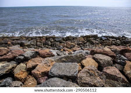 Thailand/ June 2015. Rocky shore. The rocks were placed on the edge of the ocean to prevent land erosion by the water force. It creates the unusual look that ocean next to rocks instead of sand.