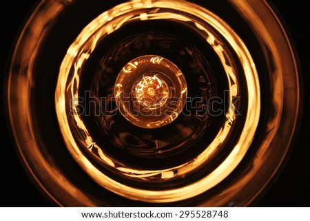 Tungsten light bulb and the light reflection creating a golden background in circles