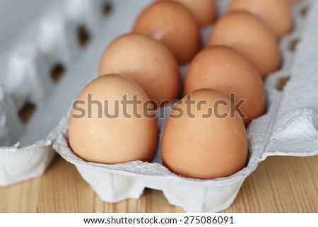 fresh chicken eggs in carton on the wooden table