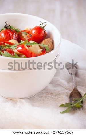 pasta with turkey , tomatoes , peppers and arugula . Italian cuisine. Tasty homemade food .