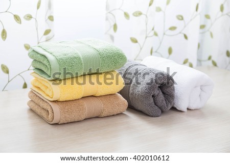 Different colors of towel in front of the cotton print curtain background