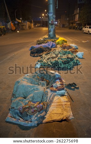 DELHI, INDIA - January 02 15: There are unidentified Indian men sleeping on the street in Delhi in the winter. There are specially many homeless and poor people in the Indian cities.