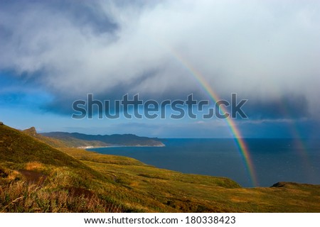 Rainbow and storm in the sea off the coast.
