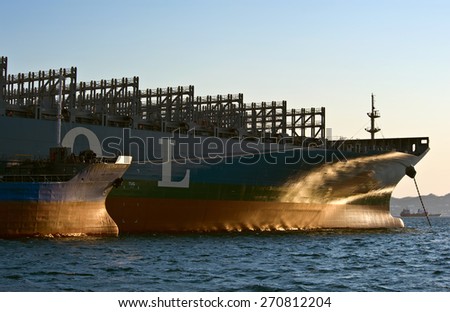 The bow of a huges tanker Russian Island and container ship MOL company at anchored in the roads. Nakhodka Bay. East (Japan) Sea. 31.03.2014