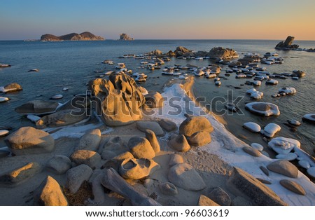 Bizarre rocks on a wild beach at sunset. Japan Sea.
