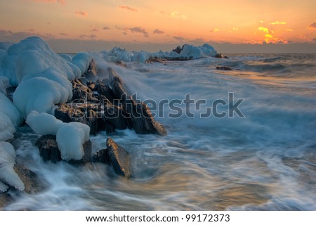 Winter seascape with storm and sea ice on coastal rocks. Japan Sea.