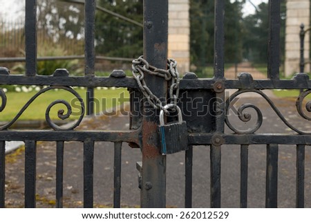 A Lock and Chain on Metal Fence Gate to the Road