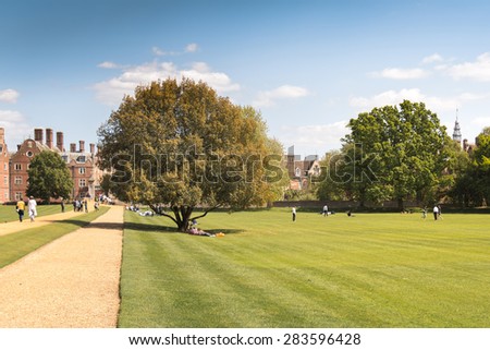 Cambridge, UK - May 16, 2015: St John College (one of University of Cambridge's college) Rear Courtyard with a huge tree and college students relaxing on Weekend.