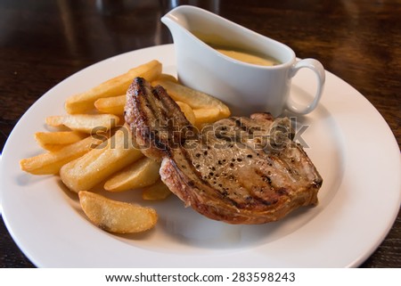Pork Chop Steak with Chips and Mushroom Sauce served on the White Plate