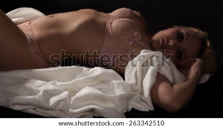 young sexy woman in lingerie lying on the back with a white blanket