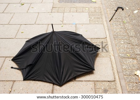 Broken Umbrella on the pavement,Bad weather.