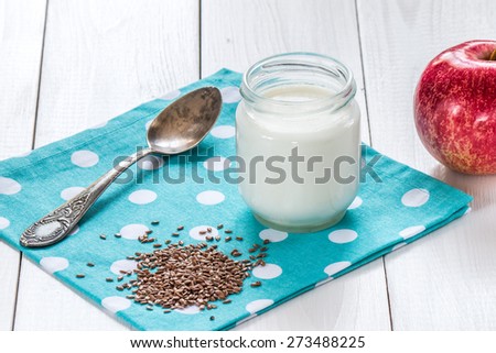 yogurt with flax  seeds and old silver spoon on  blue napkin with polka dots