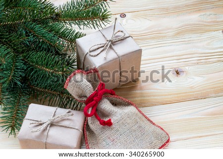 christmas gifts packaged in kraft paper and  jute rope constricted, Santa's sack  on wooden table with Christmas tree . top view, free space for text