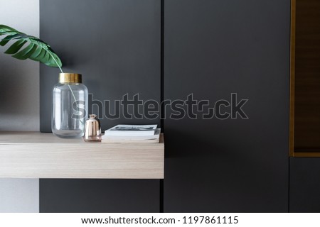 working corner decorated with books and artificial plant in gold collar glass vase on gray spray painted warbrobe / cozy interior concept / isolated for advertising