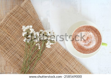 cocoa on white wooden and gunny sack background  with white flowers