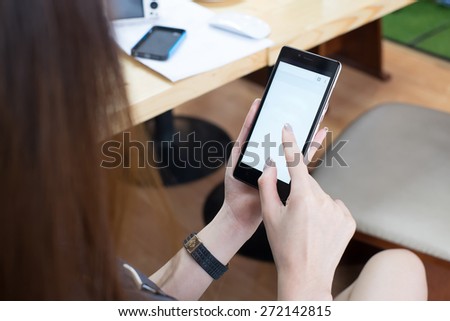 Woman  in office holding  smart phone or mobile phone with blank mobile web browser page. People use the technology for working.