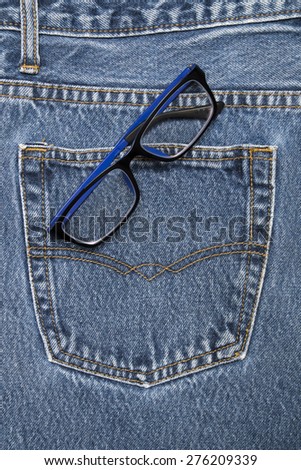 Black blue reading glasses on a denim workers pocket