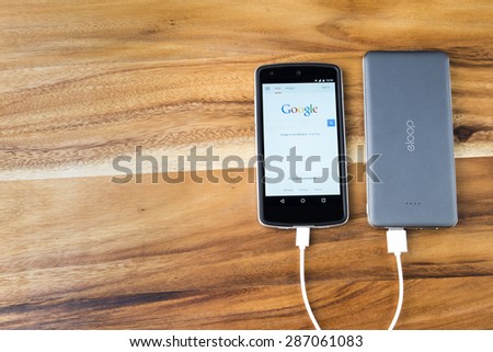 CHIANG MAI, THAILAND -JUNE 14, 2015:LG Nexus5 displaying google page and charging power with the eloop powerbank