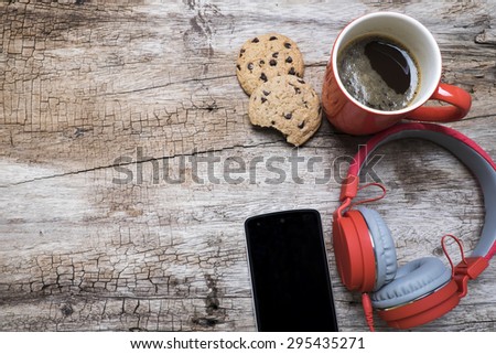 Red coffee cup, Red headphone and chocolate chip cookies on the wooden table. View from above. Coffee with chirstmas concept.