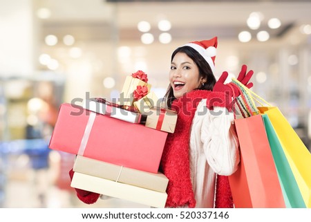 Happy girl shopping christmas gifts in shopping mall. Christmas shopping idea concept.