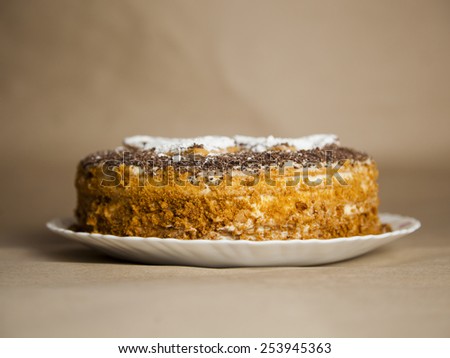 cake with chocolate crumb. Honey cake. Cake hearts. Cake on warm background. Cake on white plate. Baked cake. White powder cake. Bake food. Baking