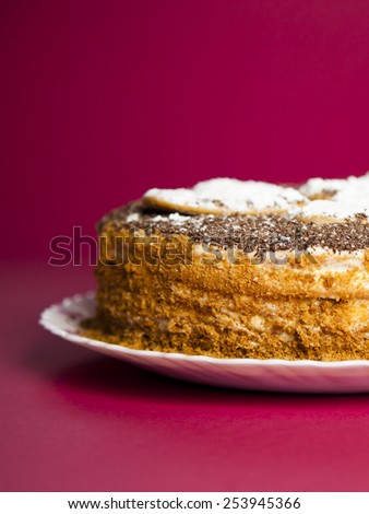 Taste cake with chocolate crumb. Honey cake. Cake hearts. Cake on red background. Cake on white plate. Baked cake. White powder cake. Bake food