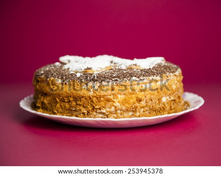 cake with chocolate crumb. Honey cake. Cake hearts. Cake on red background. Cake on white plate. Baked cake. White powder cake. Bake food. Baking
