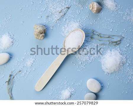 Sea salt on blue background. Spoon of salt. Sea stones. Minerals food